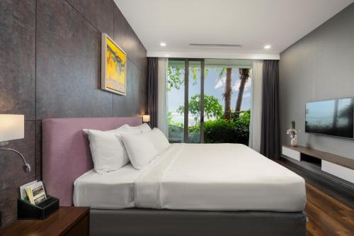 a bedroom with a large white bed and a tv at Flamingo Resort Dai Lai in Ngọc Quang
