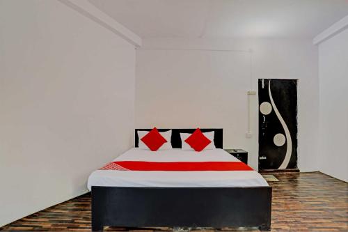 a bedroom with a bed with red and white sheets at OYO Flagship Hotel Samrat in Ghaziabad