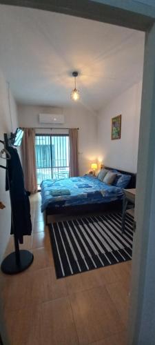 a bedroom with a blue bed and a window at Amaretto & Caffe Hostel in Surat Thani