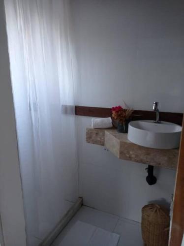 uma casa de banho branca com um lavatório e um chuveiro em Caza di Zaia - kitnet em Búzios