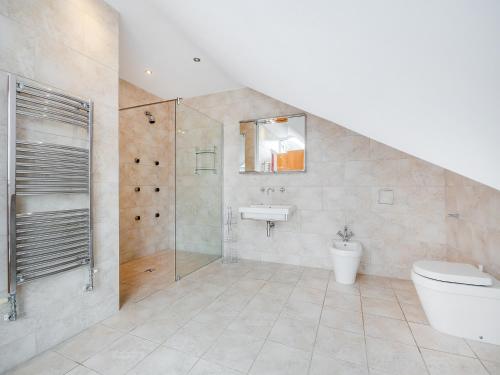 a bathroom with a shower and a toilet and a sink at The Penthouse in Morfa Nefyn