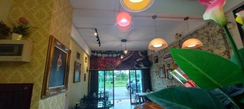 a dining room with tables and chairs and pendant lights at Amaretto Hostel in Surat Thani