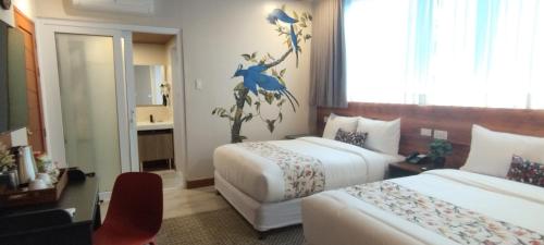 a hotel room with two beds and a bathroom at Hotel Kimberly Tagaytay in Tagaytay