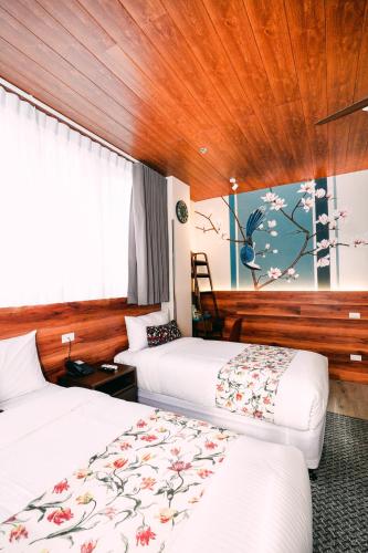 a hotel room with two beds and a window at Hotel Kimberly Tagaytay in Tagaytay