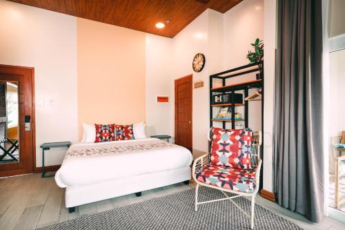 a bedroom with a bed and a chair at Hotel Kimberly Tagaytay in Tagaytay