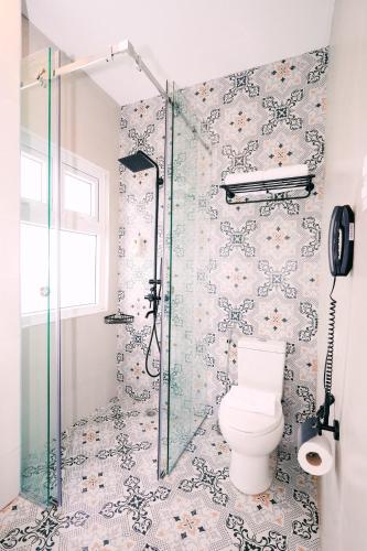 a bathroom with a toilet and a shower at Hotel Kimberly Tagaytay in Tagaytay