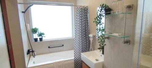 a bathroom with a tub and a sink and a shower at Hotel Kimberly Tagaytay in Tagaytay