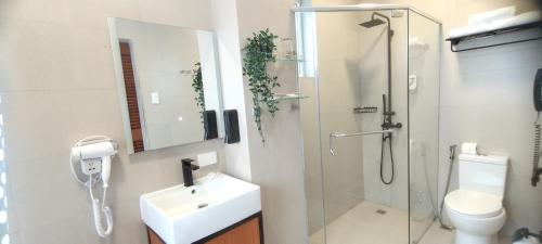 a bathroom with a shower and a sink and a toilet at Hotel Kimberly Tagaytay in Tagaytay