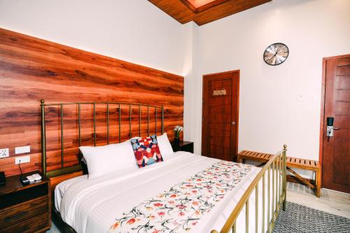 a bedroom with a bed with a wooden wall at Hotel Kimberly Tagaytay in Tagaytay