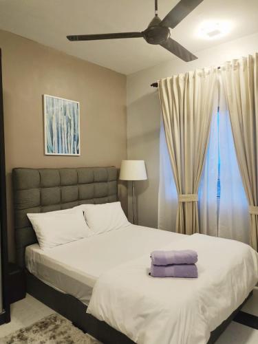 una camera con un grande letto e un ventilatore a soffitto di Mimpi D View Homestay a Kuala Terengganu