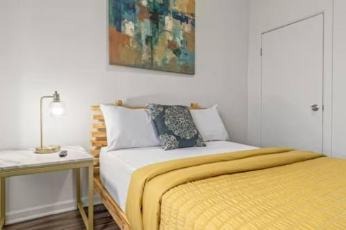 a bedroom with a bed with a yellow blanket at Urban Chic Apartments Near Center City in Philadelphia