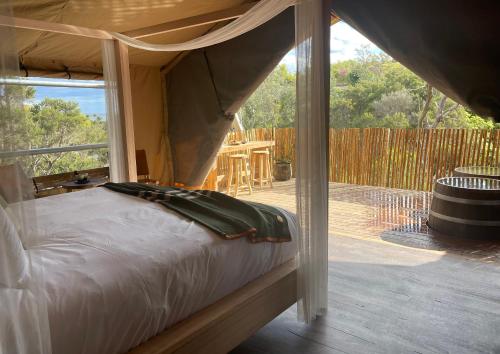 una camera con letto a baldacchino e patio di Metung Hot Springs a Metung