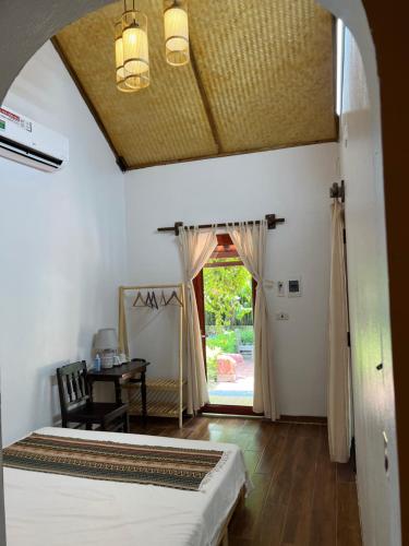 a bedroom with a bed and a table and a window at Thom's House in Ninh Binh