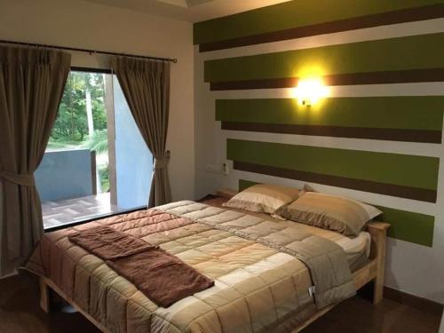 a bedroom with a bed with a striped wall at The shark resort ปราณบุรี in Ban Khao Noi