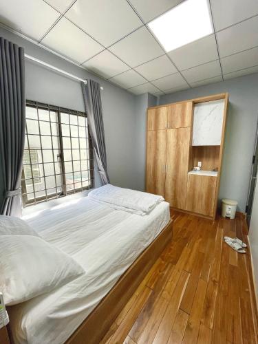 a bedroom with a large bed and a window at POTA Hotel & Apartment in Da Nang