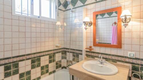 a bathroom with a sink and a mirror and a tub at Marquise House con piscina privada in Punta Umbría