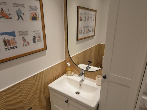 une salle de bain avec un lavabo et un miroir dans l'établissement Studio rénové au pied des pistes avec balcon et cuisine équipée - FR-1-755-9, à Aime La Plagne