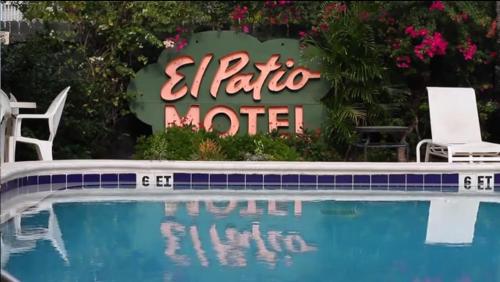 um sinal para um hotel ao lado de uma piscina em El Patio Motel em Key West
