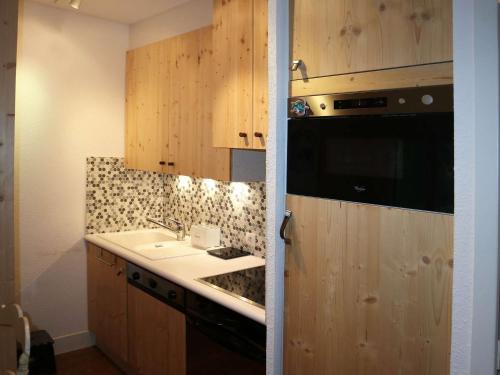 une cuisine avec un évier et un plan de travail dans l'établissement Joli duplex 7 pers aux Orres 1650 avec balcon et cuisine équipée - FR-1-322-537, aux Orres