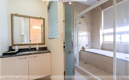 La salle de bains est pourvue d'un lavabo, d'une baignoire et d'un miroir. dans l'établissement 深溝仔庭園民宿, à Yuanshan