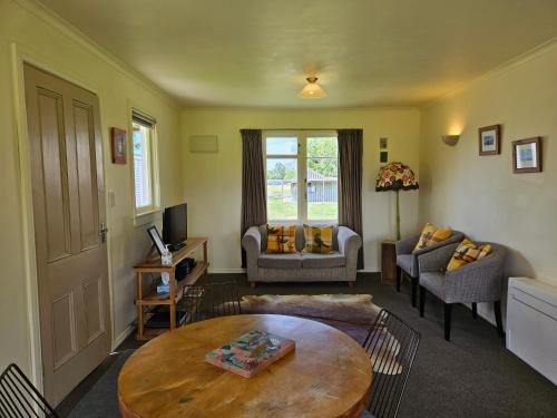 a living room with a table and a couch at The Cabin, Omahau Downs in Twizel