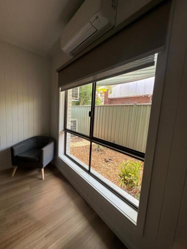 a room with a large window with a chair in it at Burrum Tavern in Burrum Heads