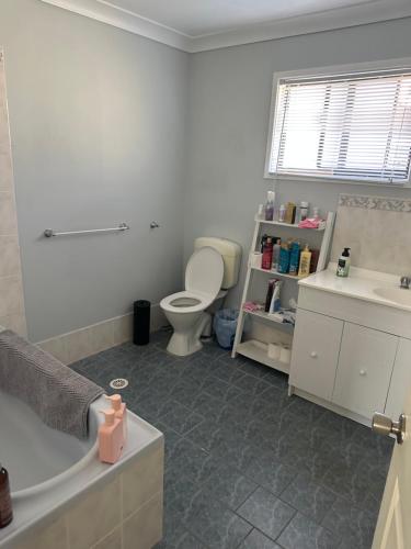 een badkamer met een bad, een toilet en een wastafel bij Comfy @ Blue Mist in Sussex inlet