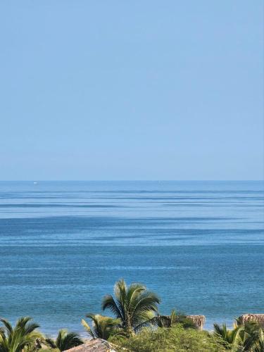 a view of the ocean from a beach with palm trees at Casa Norte North Beach in Los Órganos