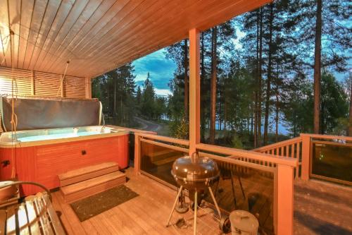 a large screened in porch with a tub on a deck at PielisLinna in Kolinkylä