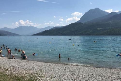 a group of people in the water at a beach at Maisonnette avec terrasse et vue imprenable in Théus