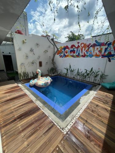 a pool in a backyard with a wooden deck at Sampai Villa D'WOO in Jetis