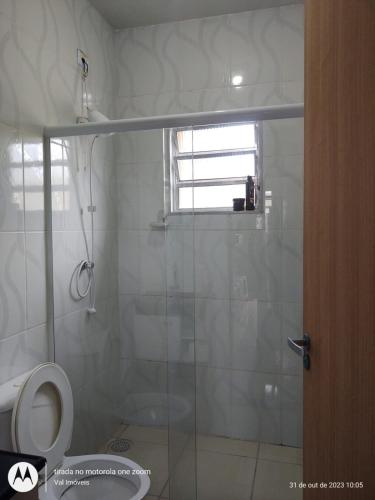 ein Badezimmer mit Glasdusche und Toilette in der Unterkunft Casa amarela cantinho de lazer in Ilha Comprida
