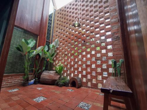 a room with a brick wall with plants in it at Pan's farm แบ่งปันฟาร์ม in Ban San Phaya Loei Luang