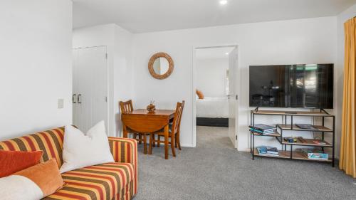 a living room with a couch and a table at Beachfront Beauty in Whangaparaoa