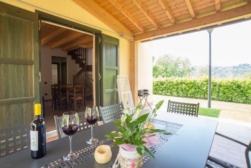 stół z dwoma kieliszkami wina na patio w obiekcie Case Vacanza Orchidea w mieście Coreglia Antelminelli
