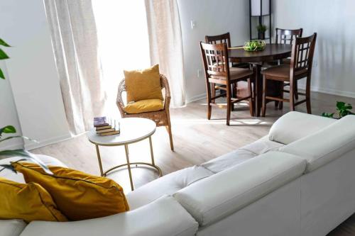 a living room with a white couch and a table at NEWLY Renovated condo 5 min from Airport in Miami