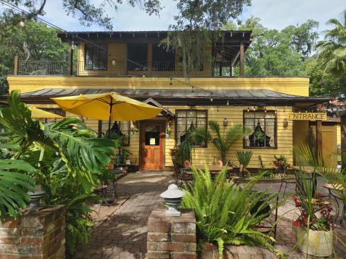 una casa amarilla con un paraguas delante en The Kind Room at the Kind House! FLETC, Traveling Professionals Welcome!, en Brunswick