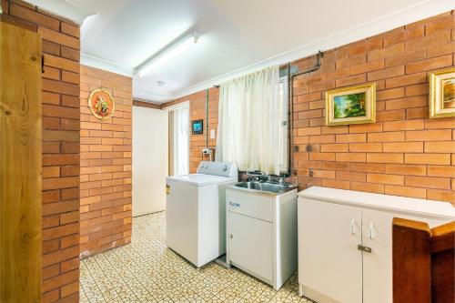 a kitchen with a brick wall and a sink at 3 Tomaree Street - Spacious 4 bedroom house with air con situated in the heart of Nelson Bay in Nelson Bay