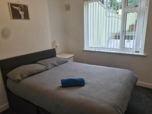 a bed with a blue bowl on it in a bedroom at L & J ESCAPES-4 BEDROOMs SUITABLE FOR CONTRACTORS AND FAMILIES- LARGE PRIVATE PARKING-10 MINUTES TO M6 JUNCTION 9 in Coseley
