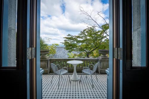 una porta che si apre su un patio con tavolo e sedie di ホテル長楽館 京都 祇園 a Kyoto