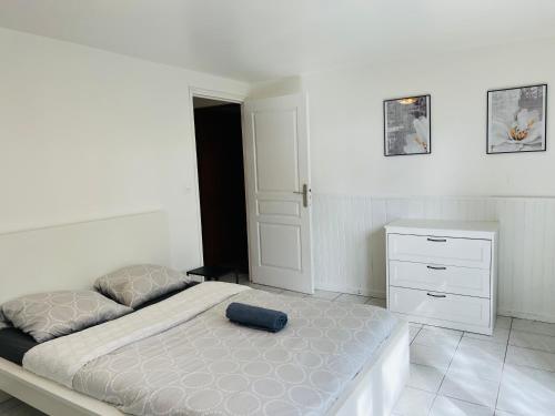 een witte slaapkamer met een bed en een dressoir bij Charmant logement centre ville Rosny Sous Bois in Rosny-sous-Bois