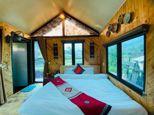 a bedroom with a large bed in a room with windows at Thoc House Ta Van in Lao Tchay