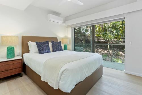 a bedroom with a large bed and a large window at The Cove Noosa - Apartment 9 in Noosa Heads