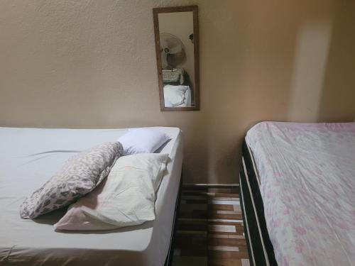 a bedroom with a bed and a mirror on the wall at Casa de praia in Goiana