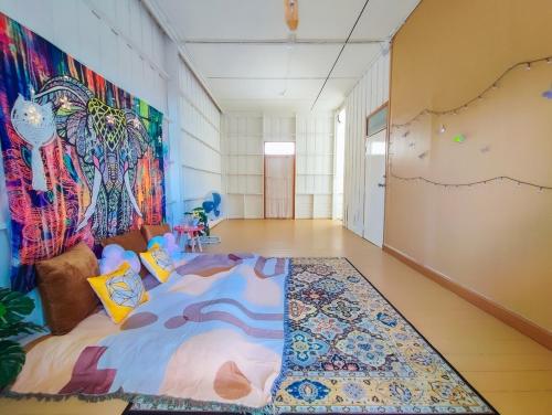 Cette chambre comprend un lit et une fresque murale. dans l'établissement GAO Marina Retro Pool Villa, à Ban Phala