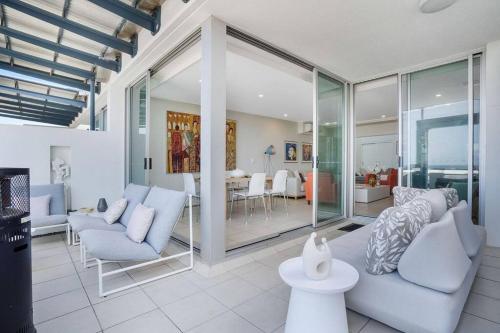 a living room with white furniture and a dining room at Lookout 334 - Endless Ocean Views - Rooftop Spa in Kingscliff