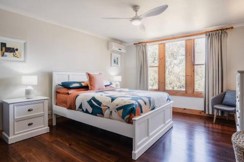 Habitación blanca con cama y ventana en Homestead Loft- Private retreat, amongst the gums with woodfire and spa bath, en Wallington