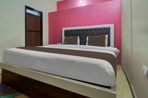 a bedroom with a large bed with a pink wall at Collection O The Legent Hotel in Jaipur