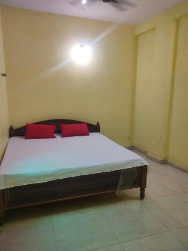 a bedroom with a bed with two red pillows at RS guest house in Katni