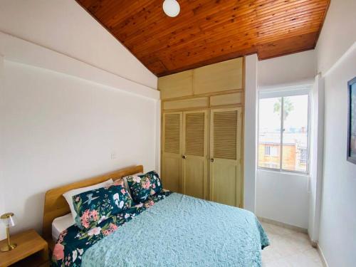 sypialnia z niebieskim łóżkiem i drewnianym sufitem w obiekcie Hermoso apartamento en Envigado w mieście Envigado